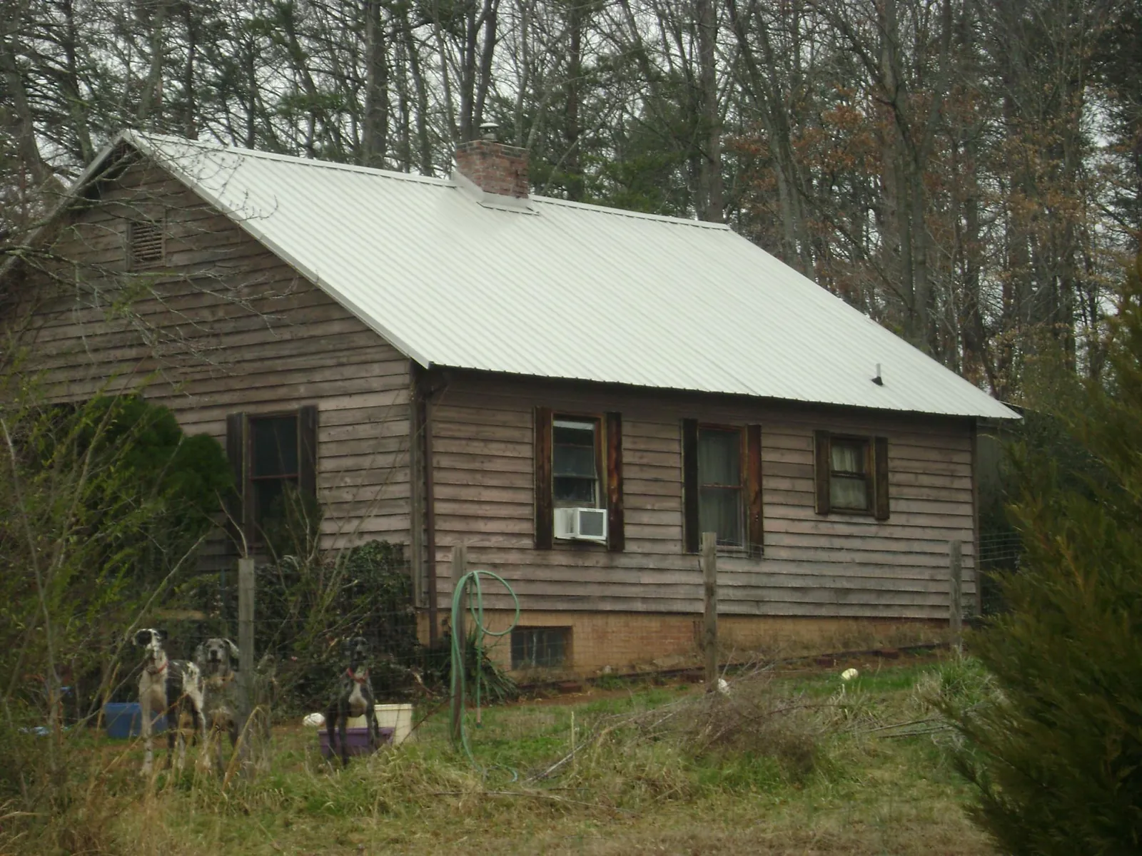 White metal roof on an old wood sided farmhouse, from a Metal Roof Installation job in Summerfield